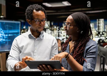 Team of programmers doing brainstorming, utilizing AI to optimize performance and forecast issues. Colleagues working together in tech startup office, training machine learning models Stock Photo