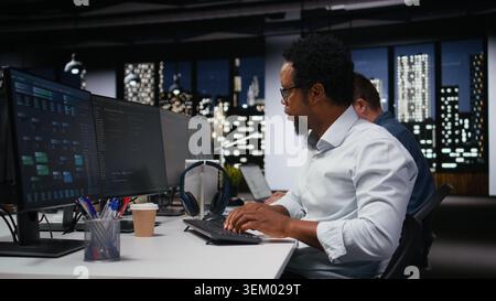 Software developer in company workplace doing artificial intelligence tech quality assurance. IT startup employee in office typing on keyboard, writing AI script with programming languages Stock Photo