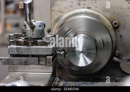 Metal turning process on industrial lathe machine in manufacturing workshop Stock Photo