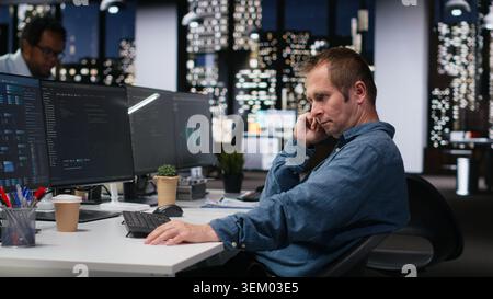 Admin in office waiting for code to finish compiling, developing machine learning models to automate tasks. Impatient startup worker bored while writing programming language scripts on PC Stock Photo