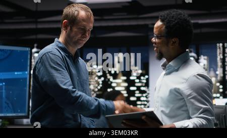 Programmers in office analyzing machine learning algorithms to prevent AI model errors. Colleagues reviewing code logic to improve artificial intelligence prediction accuracy Stock Photo