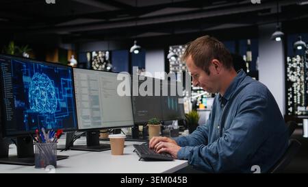 Tech startup worker drinking coffee, developing AI algorithms in high rise office. Caffeinated programmer energetically debugging neural network brain models on screens Stock Photo