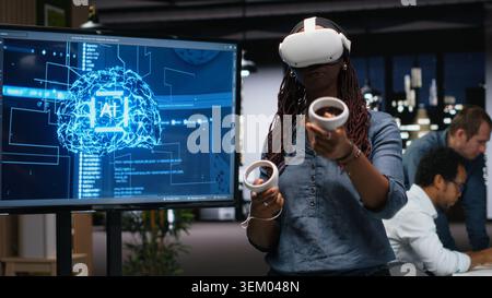 Developer in office using VR headset gear to analyze machine learning algorithms. IT expert uses virtual reality equipment to improve artificial intelligence prediction accuracy Stock Photo