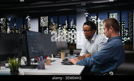 Engineering team in Silicon Valley company office developing apps with AI. Teamworking colleagues using machine learning to do coding, debugging applications to resolve issues Stock Photo