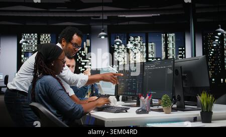 Technicians using PC in office, working with AI programming languages. Coworkers using computer in company workplace to do artificial intelligence tech quality assurance Stock Photo