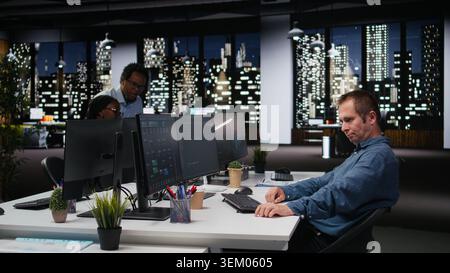 Tech agency computer scientist using AI to optimize software performance in office late at night. IT specialist at work using deep learning to analyze code and do debugging Stock Photo