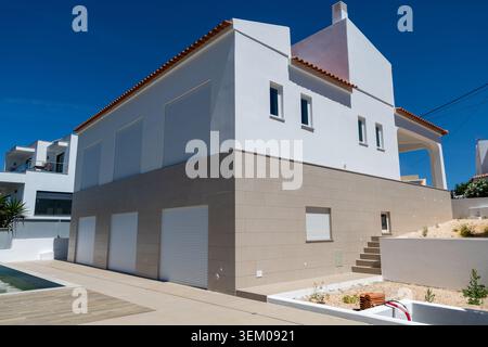 Monte Canelas Algarve Portugal, A contemporary residential building featuring a white facade, beige stone accents, and a terracotta tiled roof, set ag Stock Photo