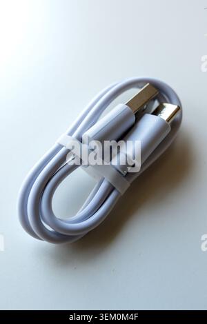 neatly coiled USB Type-C cable on a white background, representing modern technology, connectivity, and electronic accessories Stock Photo