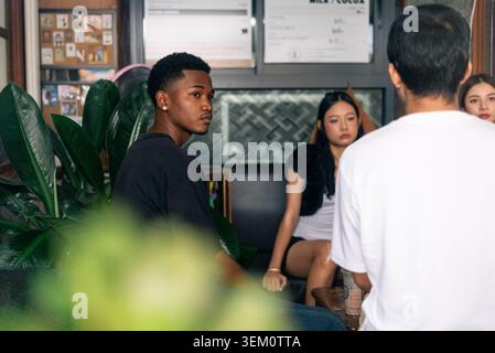 Young diverse friends relaxing at coffee shop, enjoying conversation Stock Photo