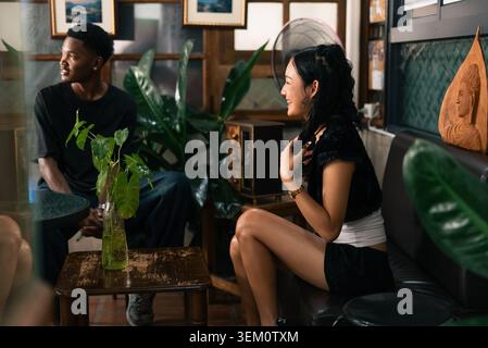 Diverse couple enjoying conversation in an informal cafe interior Stock Photo