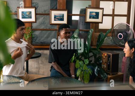 Young diverse friends meeting in cafe, conversing and discussing ideas Stock Photo