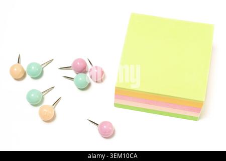Top view horizontal closeup of blank colorful sticky note pad stack with pastel push pins on white copy space background Stock Photo