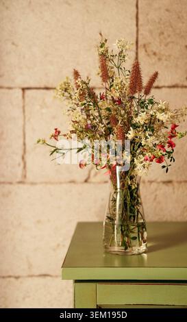 Cozy home interior with a bouquet of dried wildflowers in a vase on the table Stock Photo