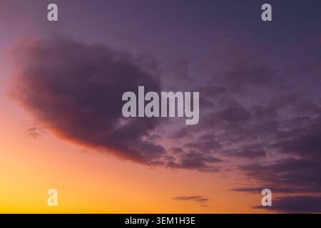Dark cloud formation against vivid purple and orange sunset sky, Los Lagos Region, Chile. Stock Photo