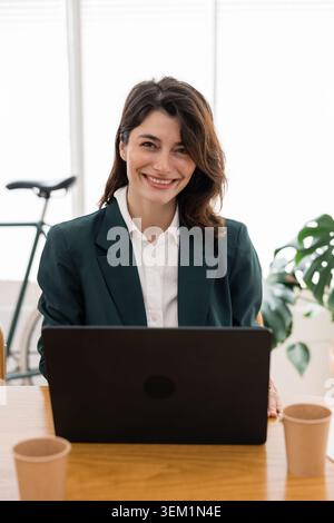 Professional woman smiling working on laptop Stock Photo