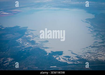 Aerial view of pale blue lake, salt flats, and road in Chobe region Stock Photo