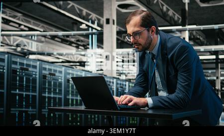 Augmented reality simulation, laptop and engineer in data center managing IT infrastructure used for database storage. Monitoring rigs, VFX compositing and man in cloud computing server farm, camera A Stock Photo