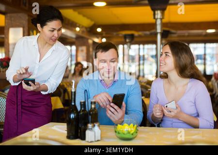 Polite asian waitress taking order from in restaurant Stock Photo