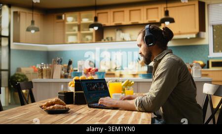 Male video editor and videographer working indoors from home, post production tasks such as timeline editing, color grading and visual effects. Interface shows clips and creative software tools. Stock Photo