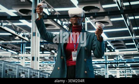 VR headset gear, AR simulation and system administrator in data center managing database storage rigs. Cloud computing, VFX visualization and worker in server room using virtual reality tech, camera A Stock Photo