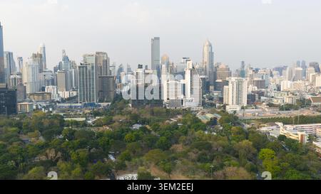 Bangkok, Thailand - 05 February 2026: Aerial view of the modern city skyline with skyscrapers rising above the lush green trees of a large urban park Stock Photo