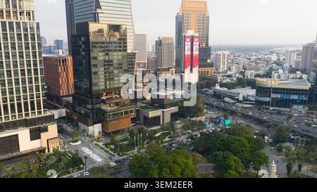 Bangkok, Thailand - 05 February 2026: Aerial view of modern skyscrapers and urban architecture with a large red billboard overlooking busy city street Stock Photo