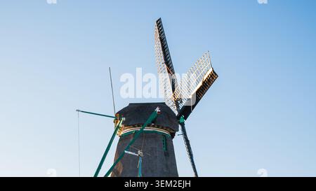 Close-up of traditional dutch windmill sails and thatched roof, historic wooden mill wings against clear blue sky with copy space in zaanse schans net Stock Photo