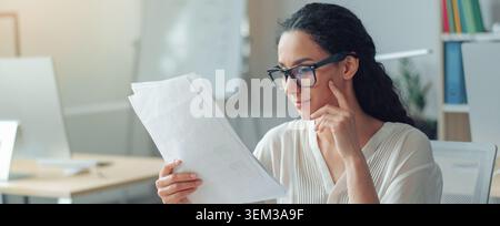 Focused Female Business Professional Analyzing Documents At Office, Business Concept Stock Photo