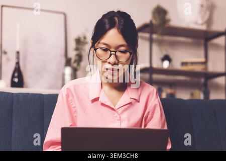 Focused Asian Female Student Using Laptop At Home, Study And Learning Concept Stock Photo