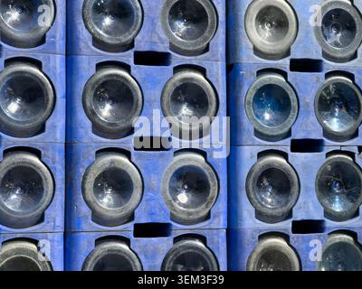 View of empty glass bottles stacked in blue plastic crates under bright sunlight in Sariyer, Istanbul, Turkey. Stock Photo