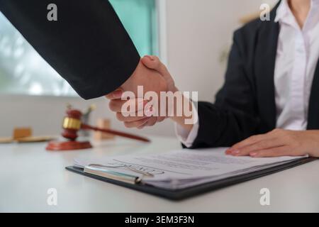 Business professionals shaking hands over signed contract Stock Photo