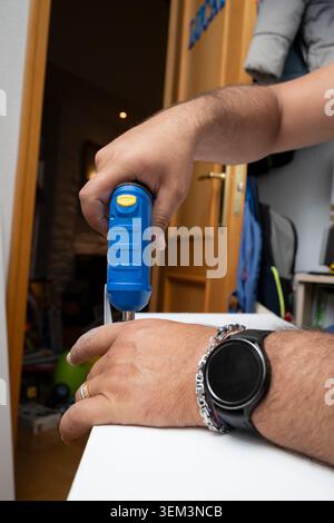Adult person using a screwdriver for house maintenance and repair Stock Photo
