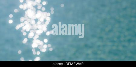 Sunlight glittering on rippled turquoise ocean water in sparkling bokeh abstract. Shimmer sea texture. Summer background design nature blue tropical Stock Photo