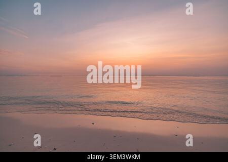Pastel sunset sky over calm tropical ocean horizon with soft pink glow. Minimal sea dusk. Summer vacation travel wellness copy space honeymoon Stock Photo