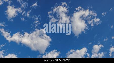 Bright blue sky fluffy white clouds on a clear sunny summer day above. Peaceful cloudscape. Design copy space nature weather heaven sky background Stock Photo