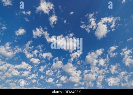 Bright blue sky with fluffy white clouds on a sunny summer day. Vibrant cloudscape natural weather backdrop. Peaceful heaven background copy space Stock Photo