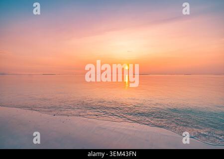 Vivid tropical sunset sun setting on calm ocean horizon. Pink orange sky glowing sea reflection. Scenic beach seascape summer travel vacation getaway Stock Photo