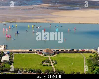 WIRRAL, MERSEYSIDE, ENGLAND - MAY 10, 2026: Sailing dinghies on West Kirby marine lake with Coronation Gardens in the foreground, Wirral peninsula, Me Stock Photo