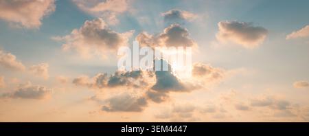 Dramatic sunbeams golden clouds over calm ocean glowing dusk sky rays through cloudscape. Summer evening seascape nature landscape. Wall art wallpaper Stock Photo