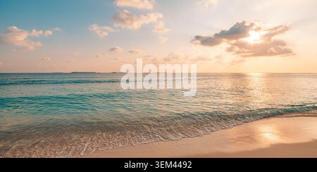 Golden sunset sky light reflecting across tropical ocean water. Warm glowing sky panoramic horizon clouds. Scenic beach seascape travel vacation view Stock Photo