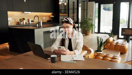 Remote work, laptop or woman with phone in home for content scheduling, comment response or email. Freelancer, social media assistant or mobile app Stock Photo
