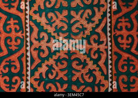 Bishkek, Kyrgyzstan - February 25, 2025: Close-up of traditional Kyrgyz ornamental felt textile with red and green motifs, photographed at the Nationa Stock Photo