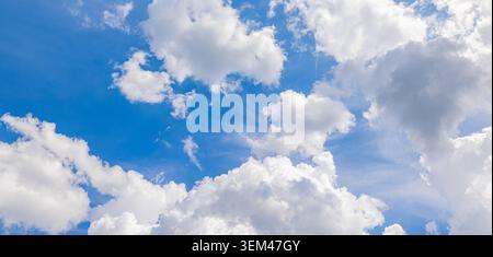 Scattered white clouds drifting across bright blue sky on clear summer day. Sunny cloudscape sunshine. Sky clouds nature background heaven copy space Stock Photo