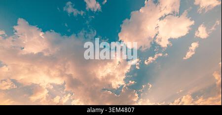 Dramatic sky glowing clouds sunbeams breaking through teal blue heaven radiant light rays. Summer cloudscape nature landscape. Wall art wallpaper art Stock Photo