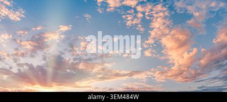 Panoramic sunset sky soft pink clouds sunbeams glowing pastel twilight horizon. Summer evening cloudscape landscape. Wall art wallpaper backdrop scene Stock Photo