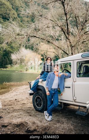 Young couple enjoying outdoor adventure with land rover Stock Photo