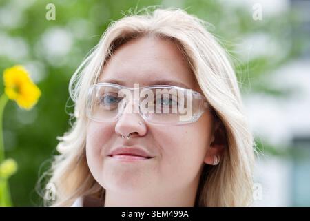 Scientist female with blonde hair outside with a flower Stock Photo