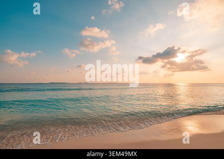 Calm turquoise sea at soft sunset, gentle surf on sandy beach under pastel clouds quiet tropical shore in warm evening light panorama scenic. Peaceful Stock Photo