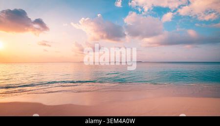 Wide pastel sunset over calm turquoise sea, soft pink clouds above smooth beach, tranquil minimal evening coastal panorama scenic. Banner background Stock Photo