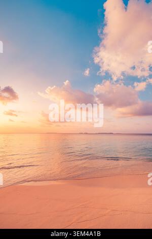 Gentle waves on empty beach at pastel dusk vertical frame, soft evening colors over tranquil sea, serene minimal tropical shore scene scenic. Wellness Stock Photo